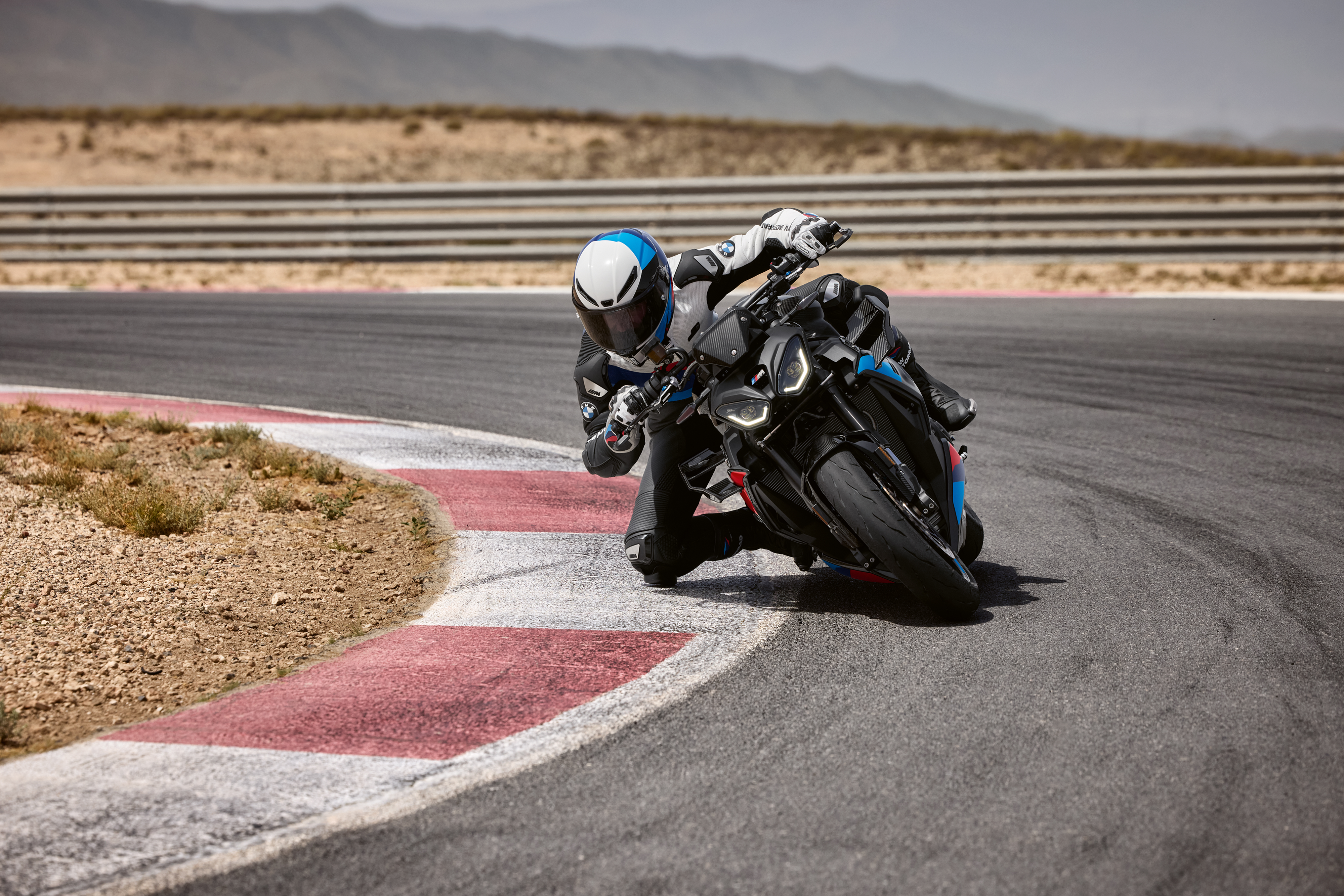 BMW M 1000 R sportbike cornering on a paved track, showcasing the precision and control provided by Marzocchi steering dampers.