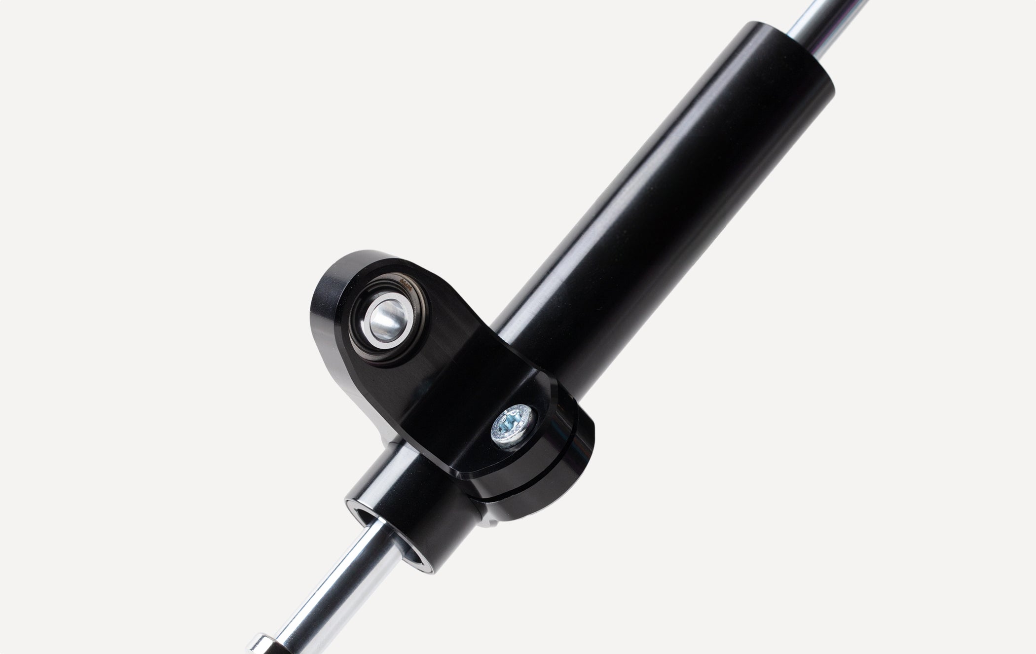 Marzocchi linear steering stabilizer mounting clamp detail, featuring a high-performance black finish and chrome piston shaft.