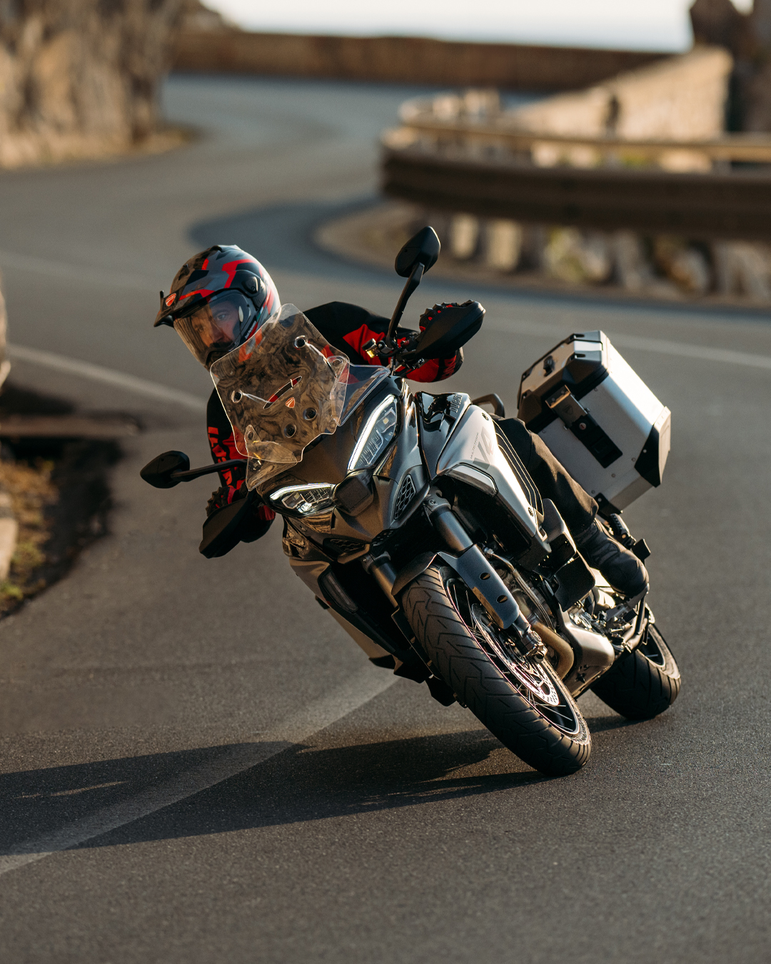 Ducati Multistrada V4 S touring motorcycle featuring Marzocchi suspension on a winding mountain pass.