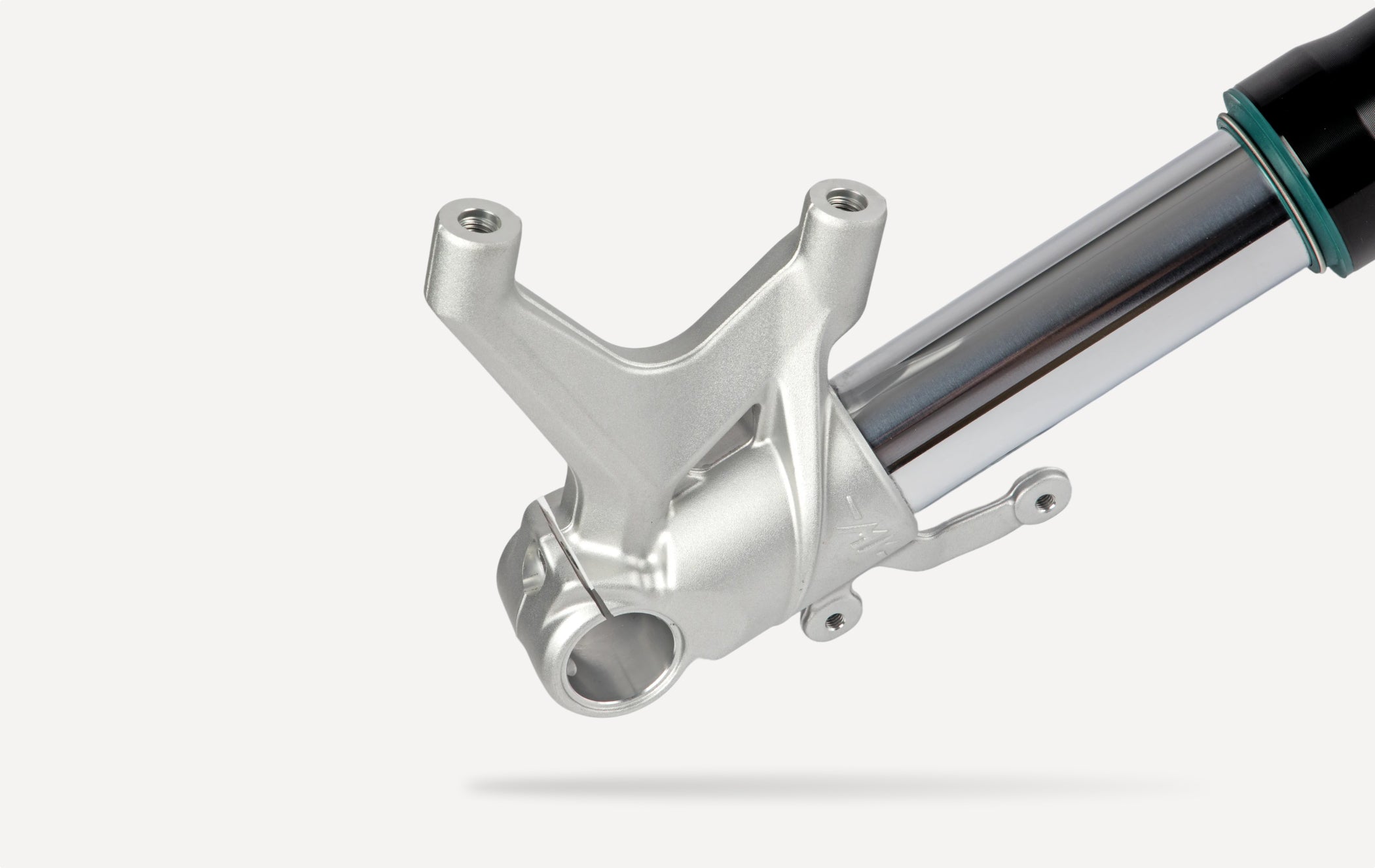 Motorcycle front fork lower leg assembly with axle clamp and mounting points for performance suspension systems.