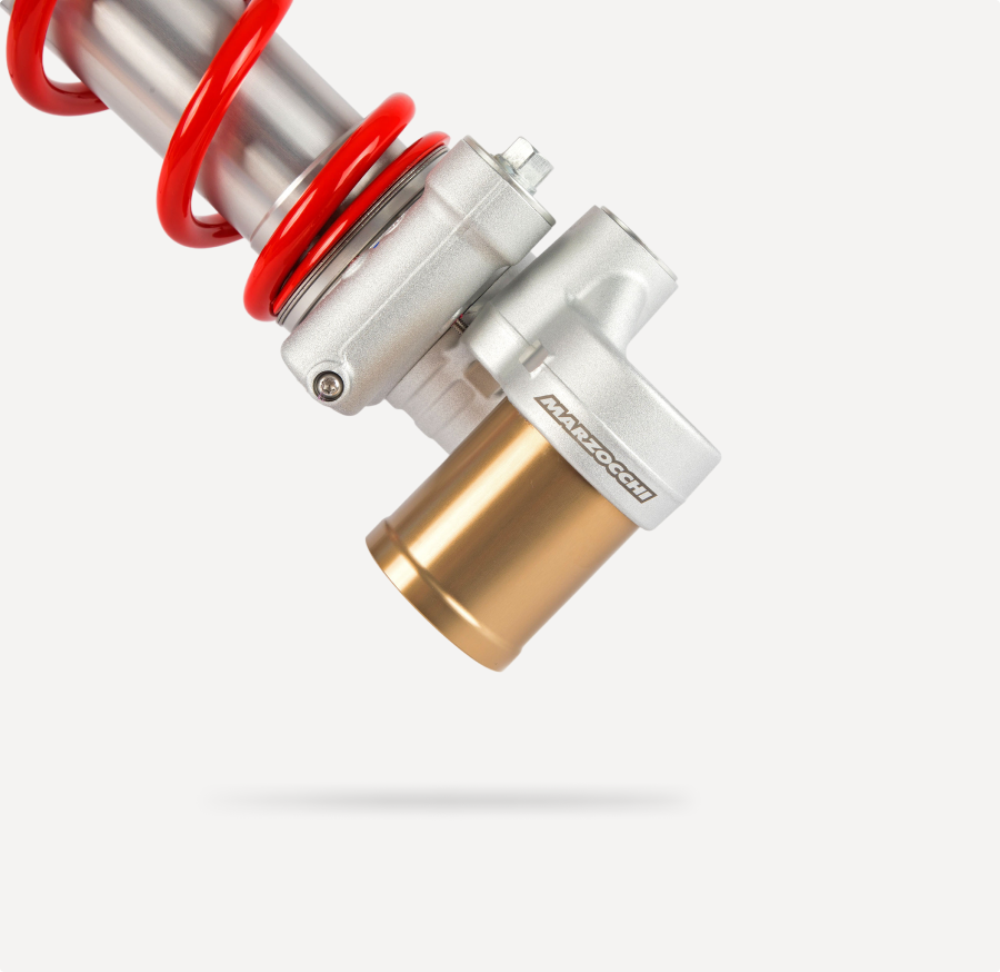 Marzocchi motorcycle rear shock absorber with red coil spring and gold reservoir.