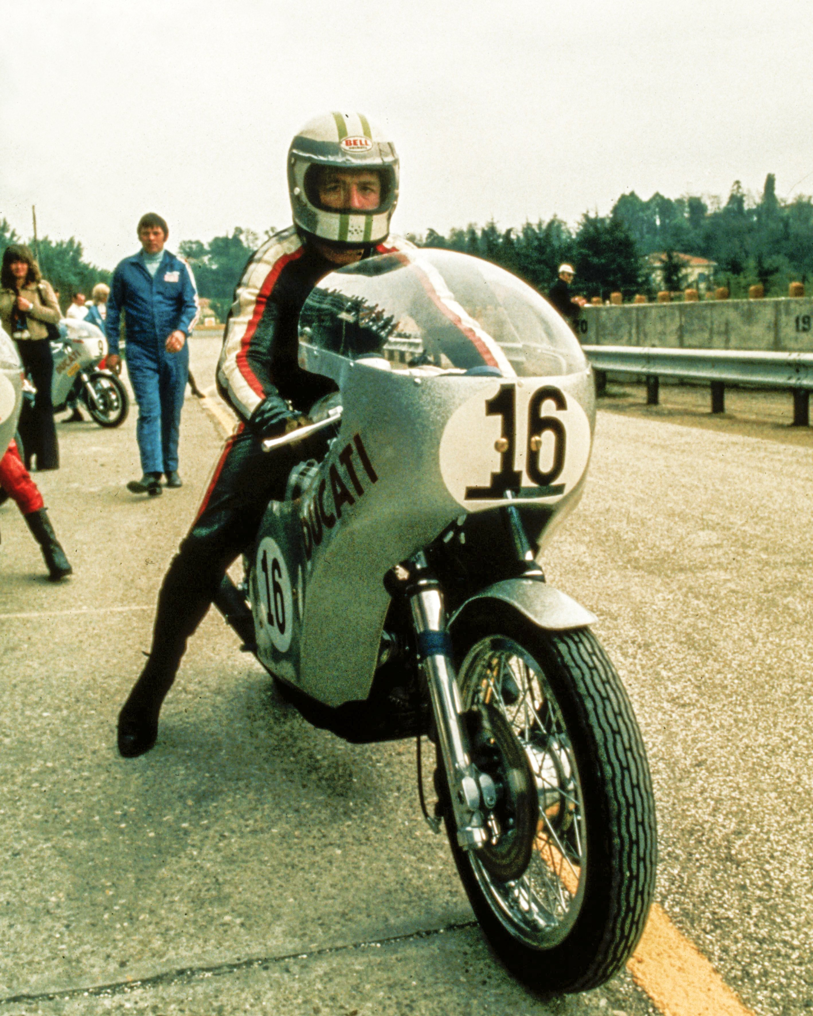 Paul Smart sitting on his #16 Ducati 750 Imola Desmo before the 1972 Imola 200, featuring the classic silver fairing and Marzocchi racing forks.