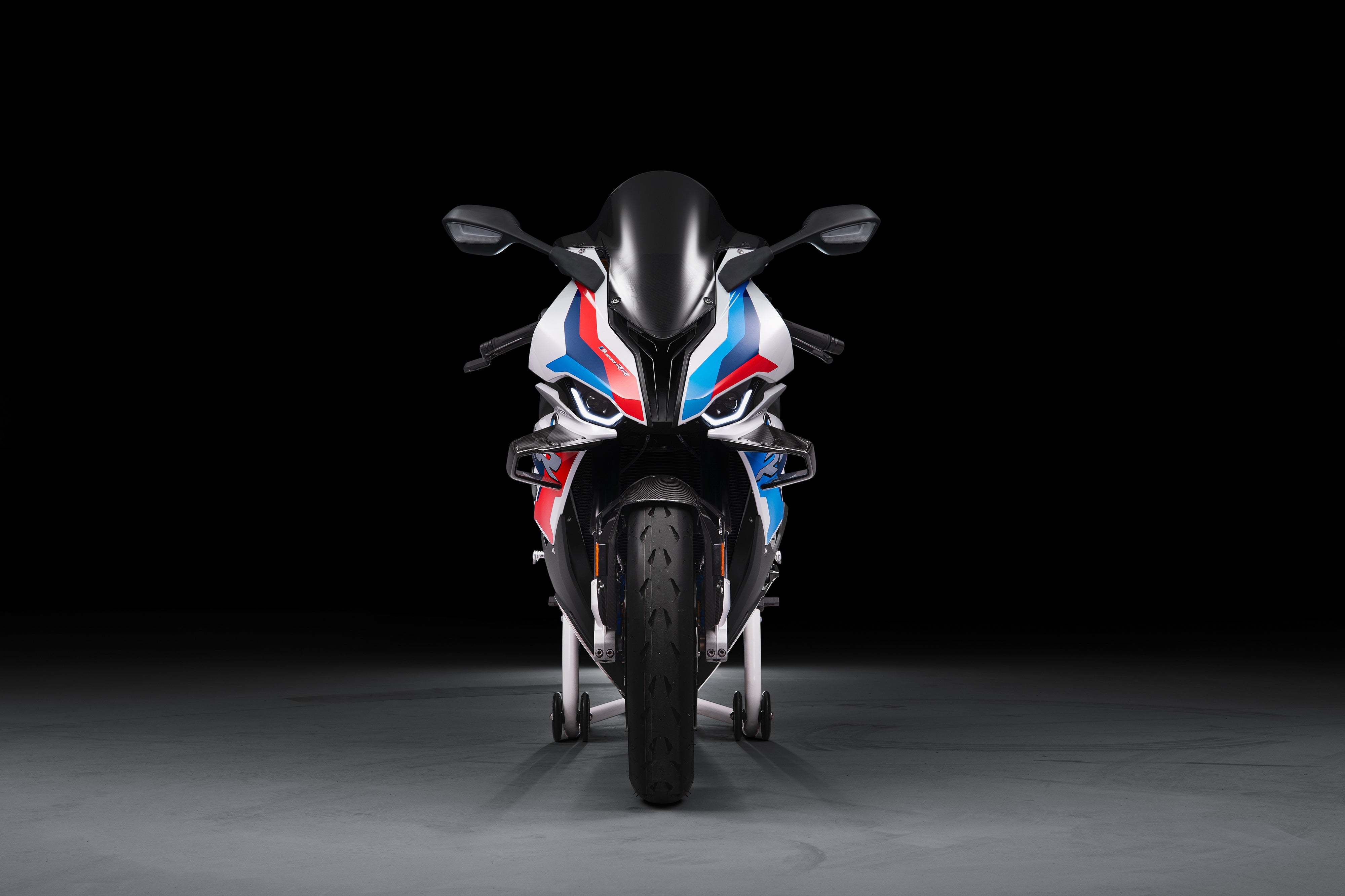 Front view of BMW M 1000 RR superbike in M Motorsport livery, showcasing aerodynamic winglets and race-engineered suspension.